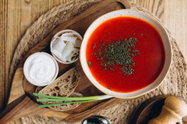 Et soslu domates çorbası ve eski ahşap arka planda maydanoz.,