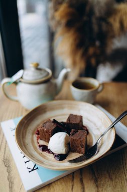 Kahveli çikolatalı kek ve ahşap masada çay.