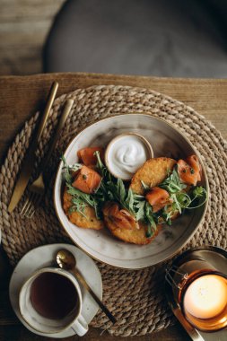 Tahta bir masada çay ve sebzelerle kahvaltı.