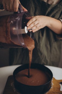 Kadın bardağa şeker döküyor.