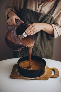 Kadın çömleğe şeker döküyor.