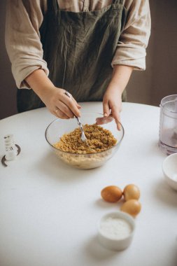 Bir kadın kaşıkla pasta yapıyor.