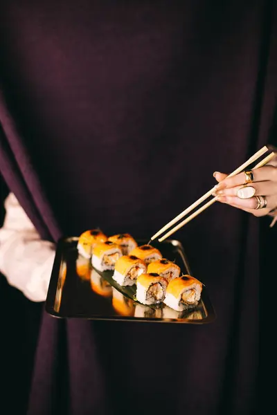 close-up of a person holding sushi in hand