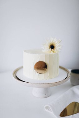 Kremalı pasta, arka planda çiçekler.