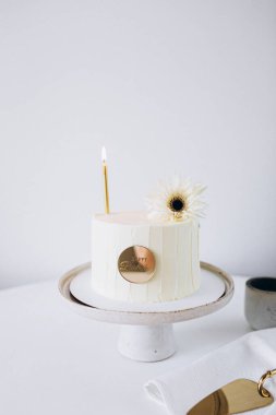 Beyaz arka planda mumları olan düğün pastası..