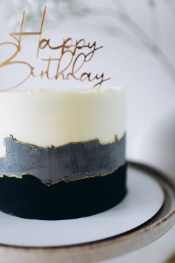 Beyaz tabakta mum olan doğum günü pastası.