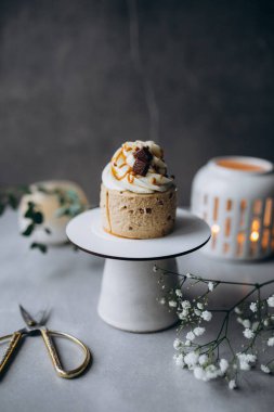 Koyu arkaplanda krema ve çikolata ile süslenmiş pasta.