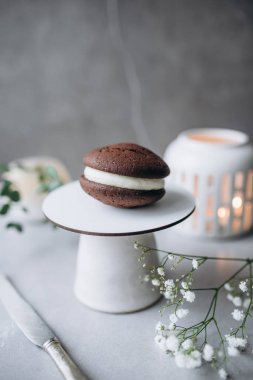 Kremalı çikolatalı pasta ve tahta masada bir fincan çay.