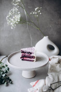 Koyu arkaplanda beyaz ve pembe çiçekli güzel bir pasta..