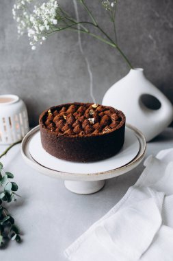 Lezzetli ev yapımı cheesecake, beyaz tabakta çikolatalı ve fincanlı.