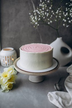 Pembe çiçekli lezzetli kekin dikey çekimi.