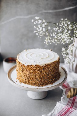 Tahta arka planda beyaz ve kırmızı krem peynirli bir dilim pasta..