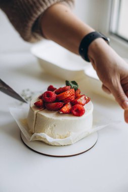 Çilekli pasta yiyen bir kadın.