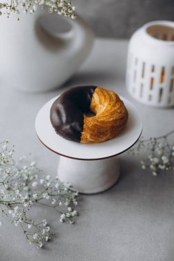 Açık arkaplanda donut olan bir tabağın dikey fotoğrafı