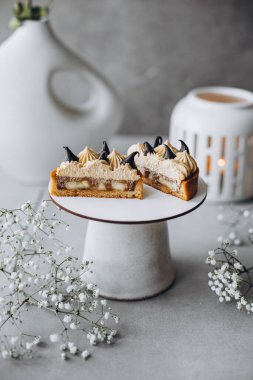 Lezzetli bir pastanın dikey yüksek açılı fotoğrafı. Bir fincan kahve ve bir parça çikolatayla birlikte.