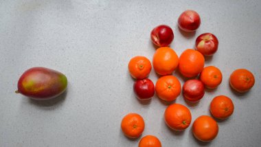 Dört meyve: bir masada mango, portakal, mandalina ve şeftali (nektarinler) 