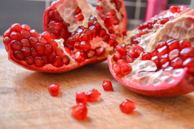 Kırmızı nar parçalanmış ve yakınlarda böğürtlenler dökülmüş.