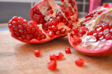 Kırmızı nar parçalanmış ve yakınlarda böğürtlenler dökülmüş.