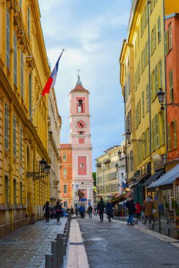 France, Nice, 11.02.2024: Eski Nice şehrinin ve katedralin arka planına karşı Fransız bayrağı