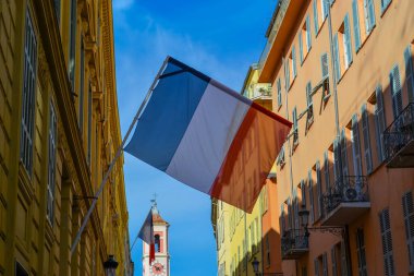 France, Nice, 11.02.2024: Eski Nice şehrinin ve katedralin arka planına karşı Fransız bayrağı