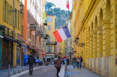 France, Nice, 11.02.2024: Eski Nice şehrinin ve katedralin arka planına karşı Fransız bayrağı