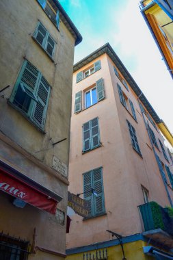 Nice, France, 13.02.2024: Architecture of the old town in Nice. A little Italian style with French motifs. Colorful houses and narrow streets. clipart