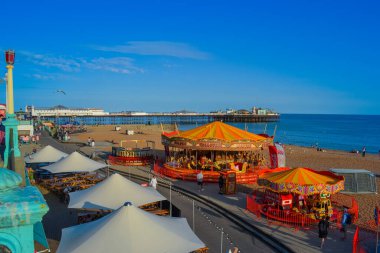 İngiltere, Brighton, 18.07.2023: Restoranlar ve atlıkarıncalarla gezinme manzarası