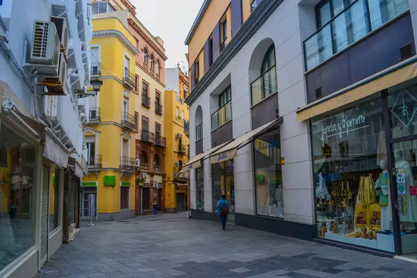 28.05.2023, Seville, İspanya: Dükkanlar, kafeler, restoranlar ve hediyelik eşya dükkanları ve renkli evleri ile Sevilla 'nın dar sokakları