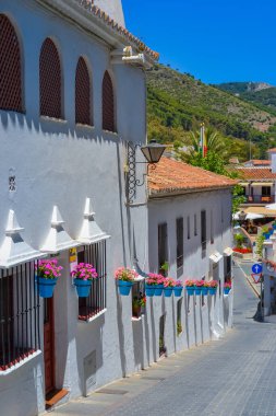 Mijas, İspanya, 28.05.2022: Dar sokaklar, balkonlar ve dağlardaki süslü evler.