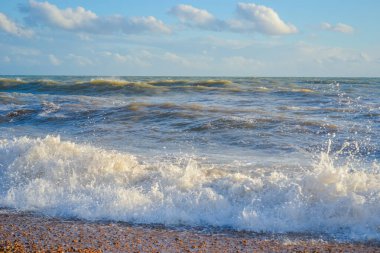 Small storm at sunset, high waves with white foam clipart