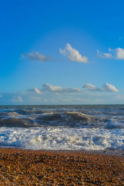 Gün batımında küçük bir fırtına, beyaz köpüklü yüksek dalgalar.