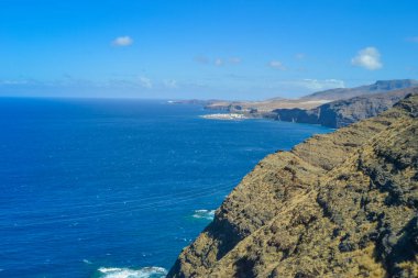 Gran Canaria adasının kuzeyindeki kayalar. Yol kayalıklardan geçer, okyanus görünür.