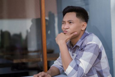 Kafede otururken kafası karışmış bir adam..