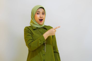 Tesettürlü genç bir kadın jesti işaret ediyor ve teşvik ediyor. Beyaz arkaplan ile reklam kavramı