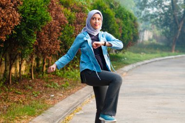 Güzel Müslüman kadın sabahları dışarıda çalışıyor. Alıştırma yaparak ısınan tesettürlü bir kadın..