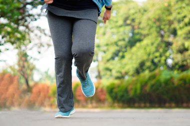 Genç, güzel Asyalı kadın dışarıda koşuyor. Sabahları egzersiz yapmak için. Sağlıklı ve aktif yaşam tarzı kavramı.