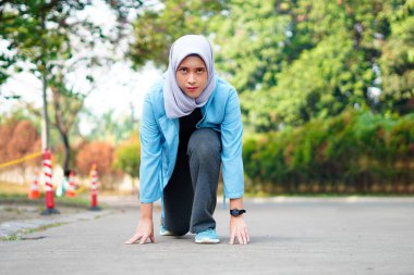 Kendine güvenen genç Asyalı kız koşuyor, spor yapıyor ve koşuya hazırlanıyor.