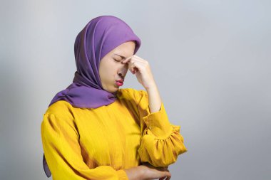 Yorgun, tesettürlü genç müslüman kadın çalışmaktan yorgun, baş ağrısı çekiyor.. 