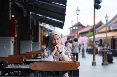 Huzurlu Düşünce konsepti. Endonezyalı Hijabi Kadını Kafe Bench 'te Kayboldu