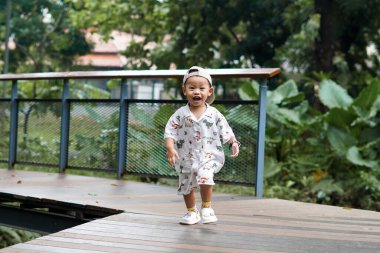 Neşeli Çocuk parkta koşuşturup, mutlu mesut oynuyor. Çocuk dışarıda koşuşturuyor..