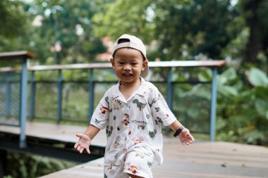 Neşeli Çocuk parkta koşuşturup, mutlu mesut oynuyor. Çocuk dışarıda koşuşturuyor..