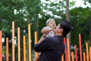 Baba sevgisi. Parkta oğluyla oynayıp bağ kuran, oğlunu taşıyıp kaldıran bir baba..