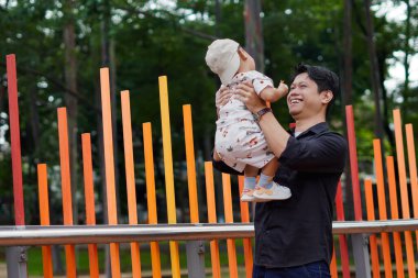 Baba sevgisi. Parkta oğluyla oynayıp bağ kuran, oğlunu taşıyıp kaldıran bir baba..