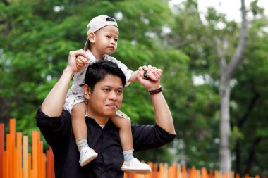Baba sevgisi. Parkta oğluyla oynayıp bağ kuran, oğlunu taşıyıp kaldıran bir baba..