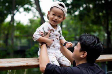 Baba sevgisi. Parkta oğluyla oynayıp bağ kuran, oğlunu taşıyıp kaldıran bir baba..