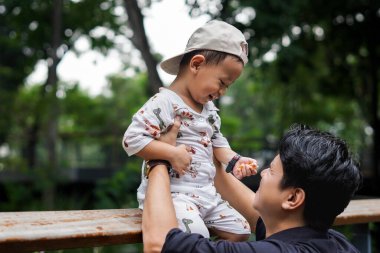 Baba sevgisi. Parkta oğluyla oynayıp bağ kuran, oğlunu taşıyıp kaldıran bir baba..