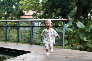 Neşeli Çocuk parkta koşuşturup, mutlu mesut oynuyor. Çocuk dışarıda koşuşturuyor..