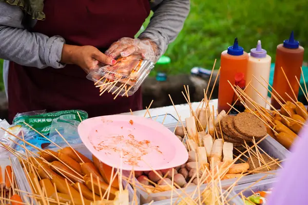 Woman packaging sausage on street food festival