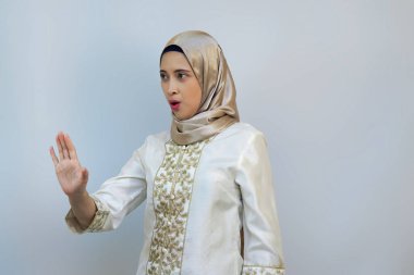 Indonesian woman posing with open palm as if prohibiting someone clipart