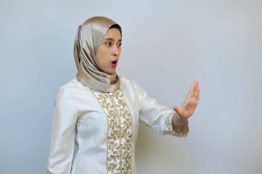 Endonezyalı kadın sanki birini yasaklıyormuş gibi avuç içi poz veriyor.